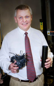 U mechanical engineering professor Dan Adams holds two carbon/epoxy tube specimens used to assess composite crash worthiness. The one on the right is before testing. On the left is after crush testing, showing the high degree of fragmentation and thus high-energy absorption.